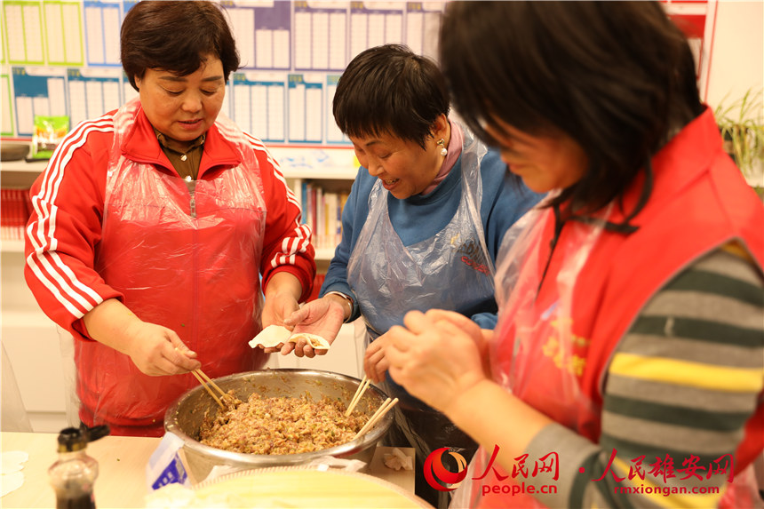 圖為容西片區(qū)飛泉社區(qū)組織回遷居民包餃子。人民網(wǎng) 楊華龍攝